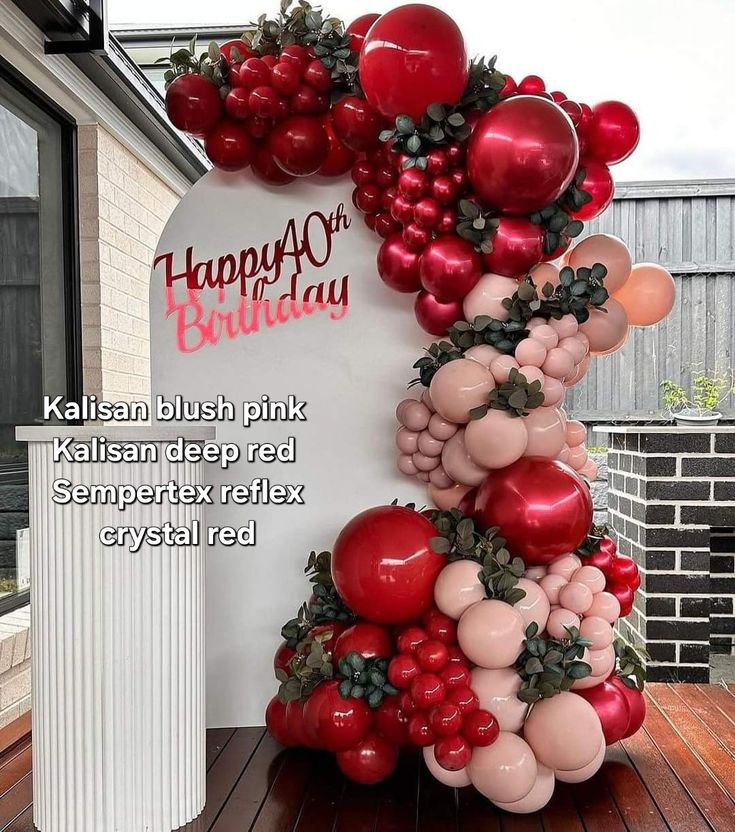 the balloon arch is decorated with red and pink balloons