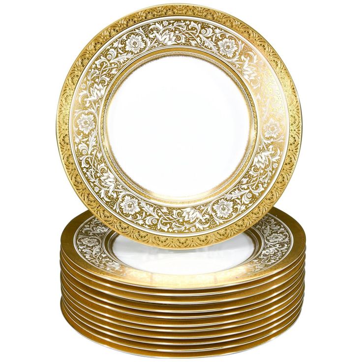 a stack of gold plates sitting on top of each other in front of a white background