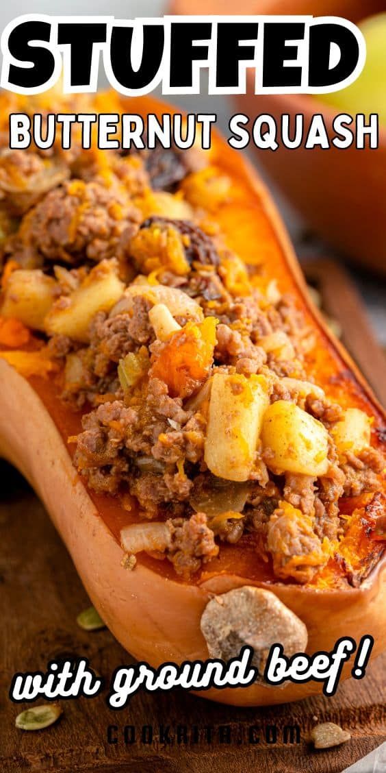 stuffed butternut squash with ground beef on a wooden cutting board next to an apple