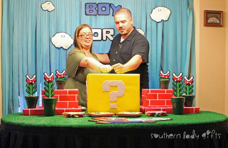 a man and woman standing in front of a giant question mark made out of lego blocks