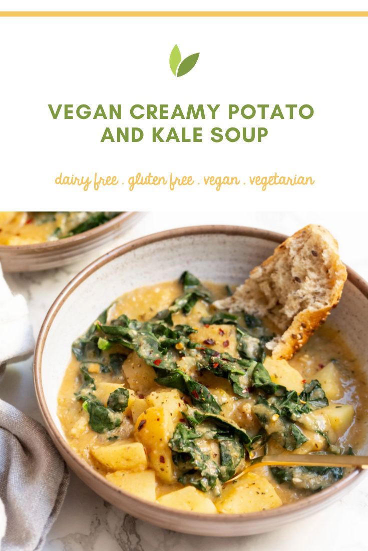 vegan creamy potato and kale soup in a bowl with a piece of bread on the side