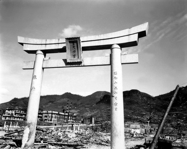 an old photo of a large wooden structure in the middle of a city with mountains in the background