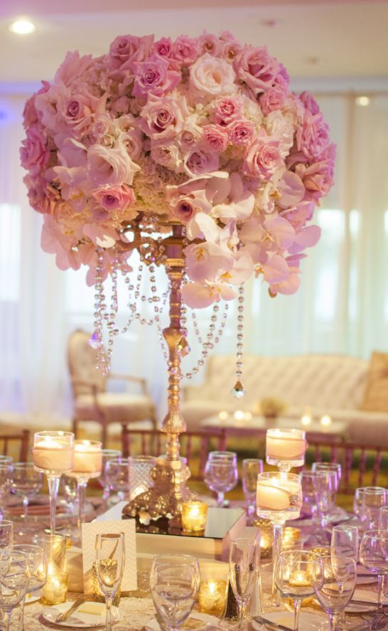 the centerpiece is adorned with pink flowers and candles for an elegant touch to the table