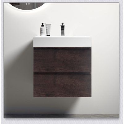 a white sink sitting under a mirror next to a wall mounted faucet with two soap dispensers on it