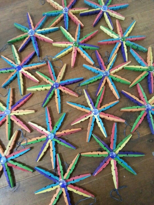 colorful paper stars are arranged on a wooden surface with string attached to the top and bottom