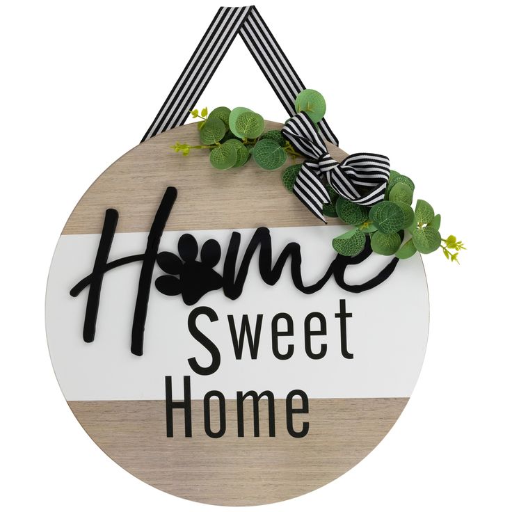 a wooden sign that says home sweet home with green leaves on the front and side