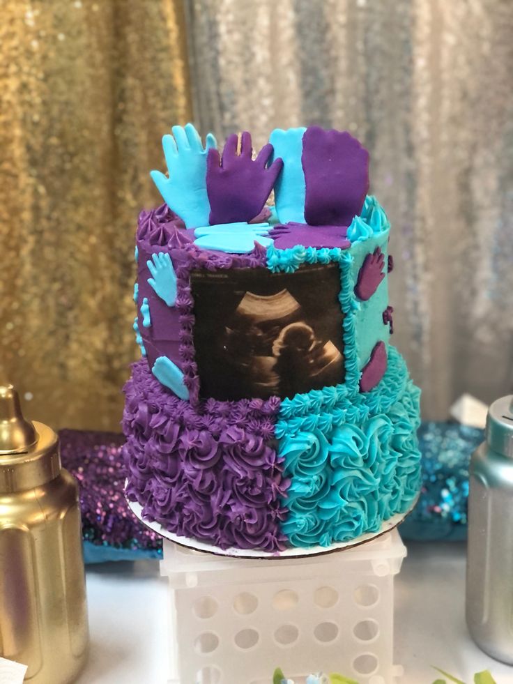 there is a cake decorated with purple and blue icing on the table next to other decorations