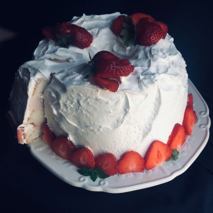 a cake with white frosting and strawberries on top