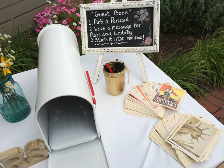 a white table topped with lots of cards and a chalkboard on top of it