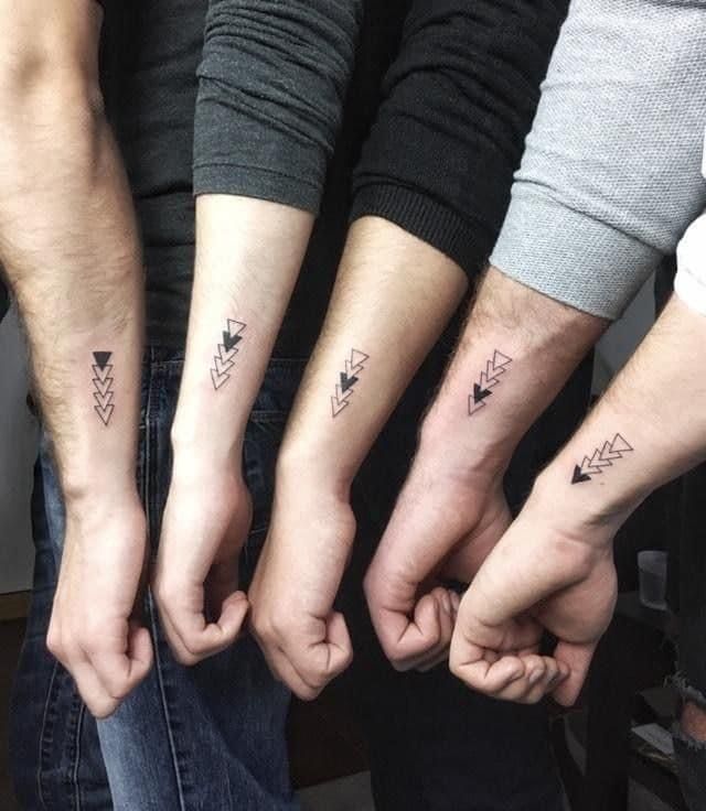 three people holding hands with small tattoos on them