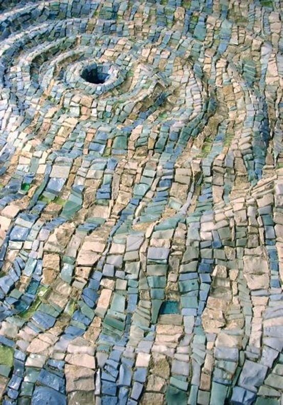 a close up view of a mosaic tile floor with a circular hole in the center