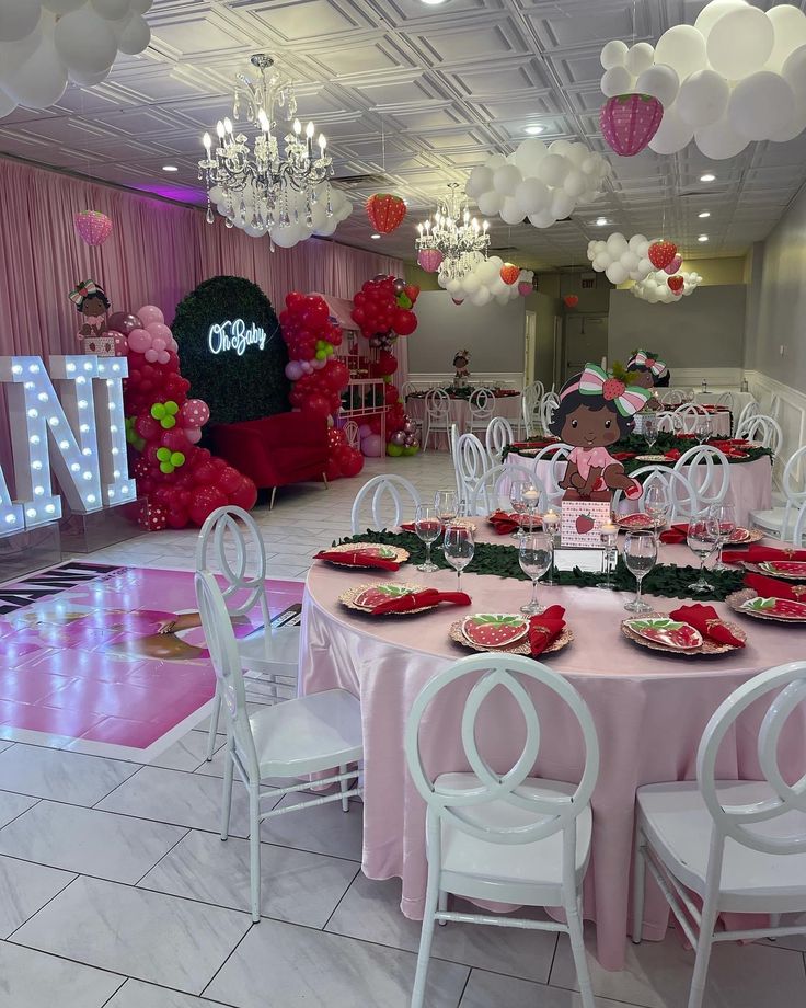 a table set up for a party with pink and white decor