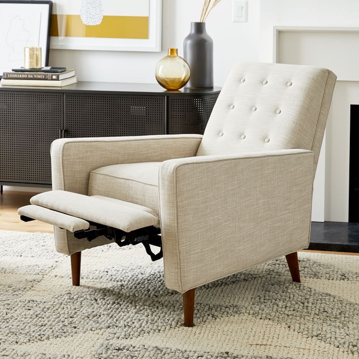 a living room scene with focus on the reclining chair and fireplace in the background