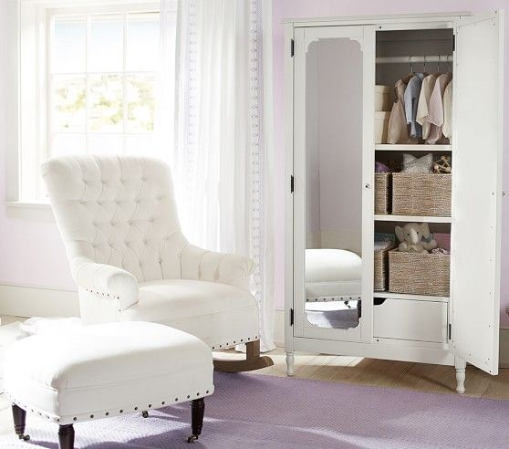 a white chair sitting in front of a closet