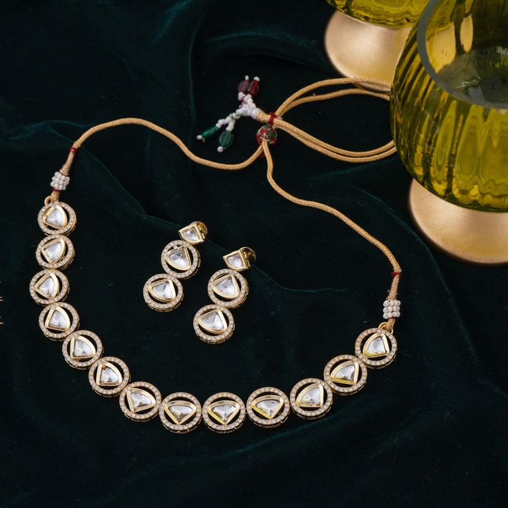 Step-in to the aura of timeless elegance with this must-have piece adding a touch of class to any ensemble! Embellish your look with subtle sophistication and enhance your style with this exquisite set crafted with luxurious and dazzling polki jadau kundan stones. The set includes a necklace and a pair of push-back earrings. Approximate earrings length is 1.5". Gold-plated on high-quality brass as base metal. In-stock & ready-to-ship. *Please Note: We use faux stones and beads in all of our jewe Gold Kundan Sets For Reception, Elegant Kundan Sets With Meenakari Detailing, Festive Kundan Sets With Hand Set Detailing, Bollywood Style Festive Jewelry Sets With American Diamond, Diwali Festive Gold-plated Kundan Necklace, Diwali Festive Gold Plated Kundan Necklace, Bollywood Style American Diamond Jewelry Sets For Festive Occasions, Festive Jewelry Sets For Reception, Festive American Diamond Bridal Sets