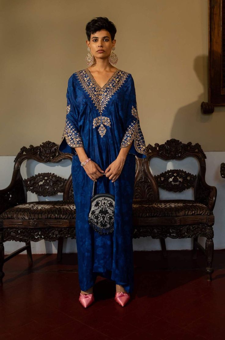 Editor's Note Featuring a deep blue self-woven kaftan with hand embroidery on yoke and cuffs. This elegant piece comes embellished with careful antique embroidery detailing. Color: Blue Fabric: Russian jacquard Component: Kaftan Fit: Relaxed Occasion: Resort and evening wear Care: Dry Clean Only About the Designer Paulmi & Harsh is a luxury prêt label inspired by beautiful botanicals. Paulmi & Harsh design strong, feminine silhouettes with prints and delicate detailing, fusing 1950’s fashion wit Kaftan Set, Strong Feminine, Soothing Nature, 1950’s Fashion, Antique Embroidery, Timeless Outfits, Embroidery Detailing, Dress Pattern, Beautiful Hand