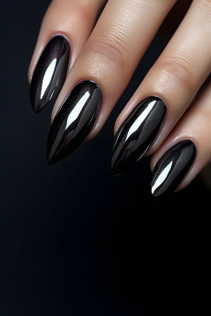 a woman's hand with black and silver nail polish on her nails, dark background