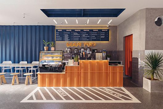 the interior of a coffee shop with blue and orange striped walls, white chairs and tables