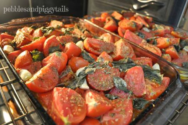 tomatoes and other vegetables cooking in an oven