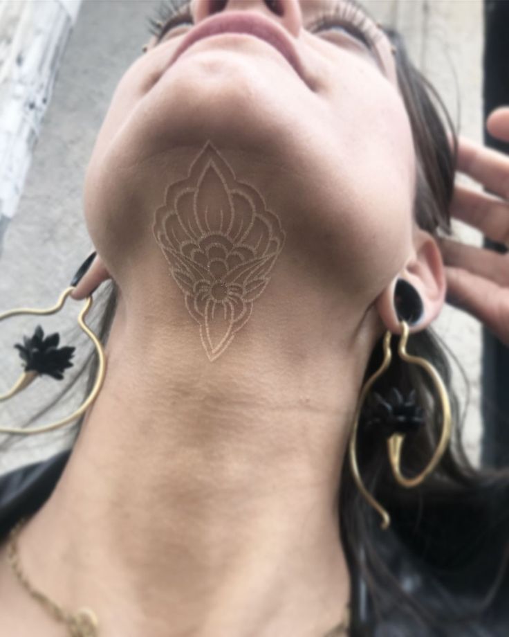 a woman with a tattoo on her neck is looking up at something in the air