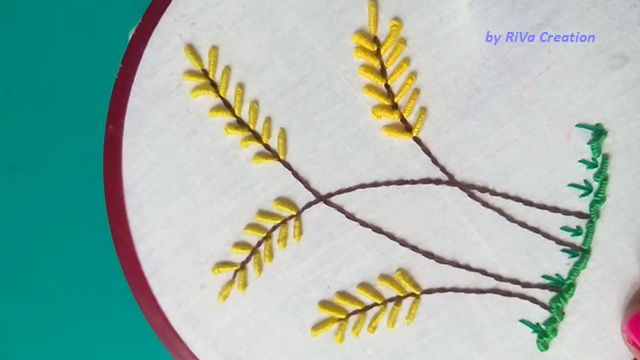 the embroidery is being worked on by a person with a pink manicure and a pair of scissors