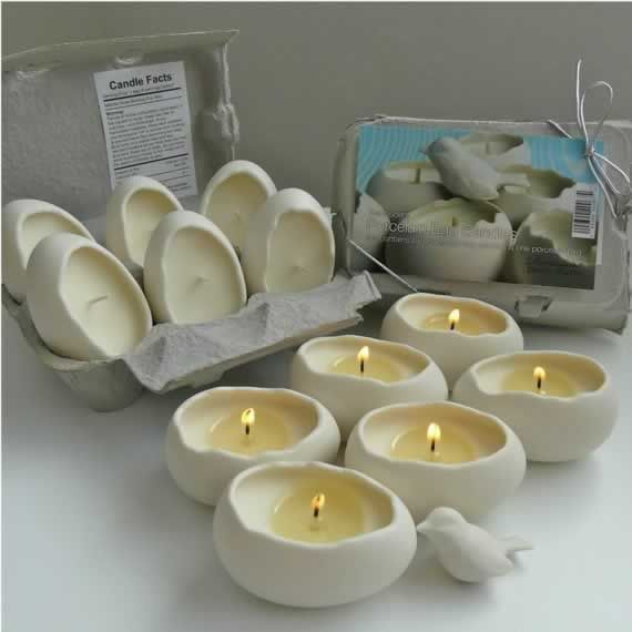 there are many white candles in bowls and one has a small bird on the side