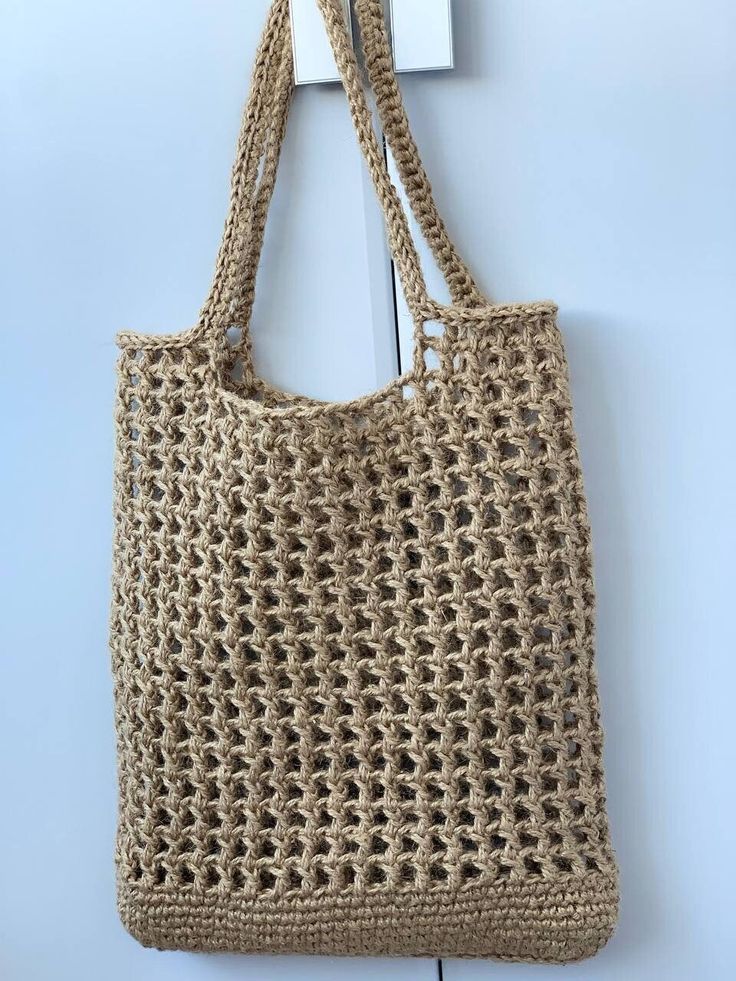 a crocheted bag hanging on the wall