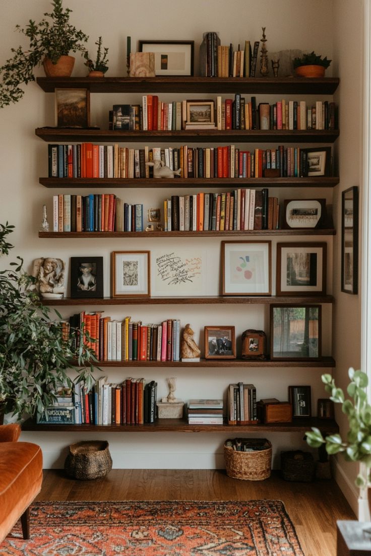 a bookshelf filled with lots of books next to a couch and potted plant