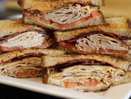 a pile of sandwiches sitting on top of a white plate