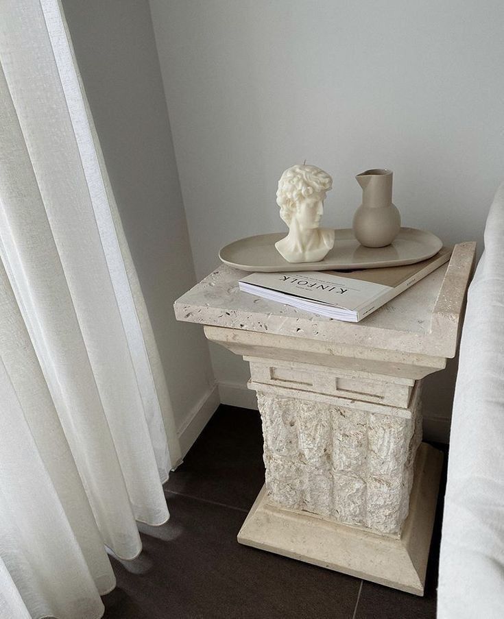 a small table with a vase and book on it