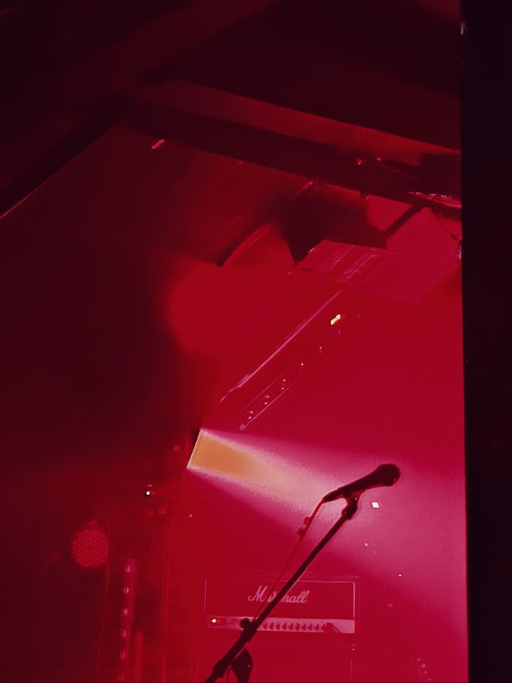 a microphone on stage in front of a red light