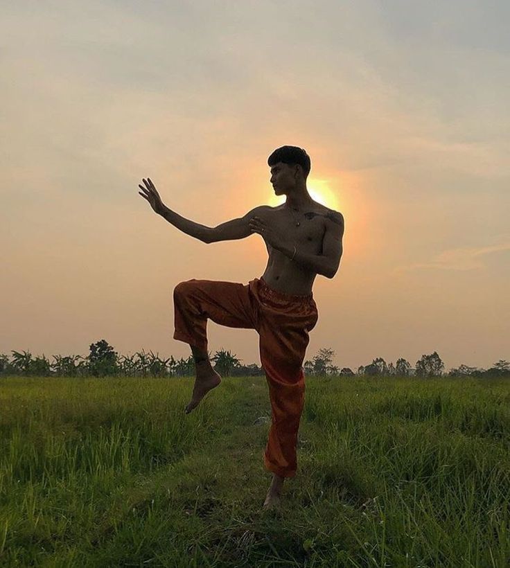 a man standing on one leg in the middle of a field