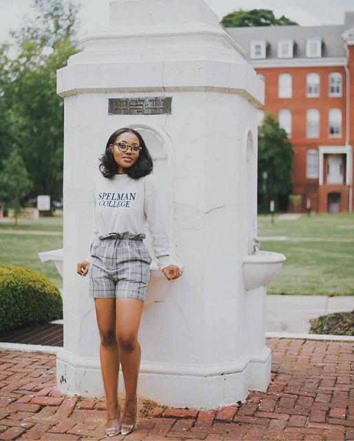 a woman standing in front of a white monument with her hands on her hips and looking at the camera