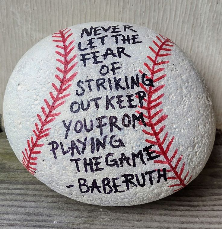 a baseball with the words never let the fear of striking out keep playing the game babe ruth