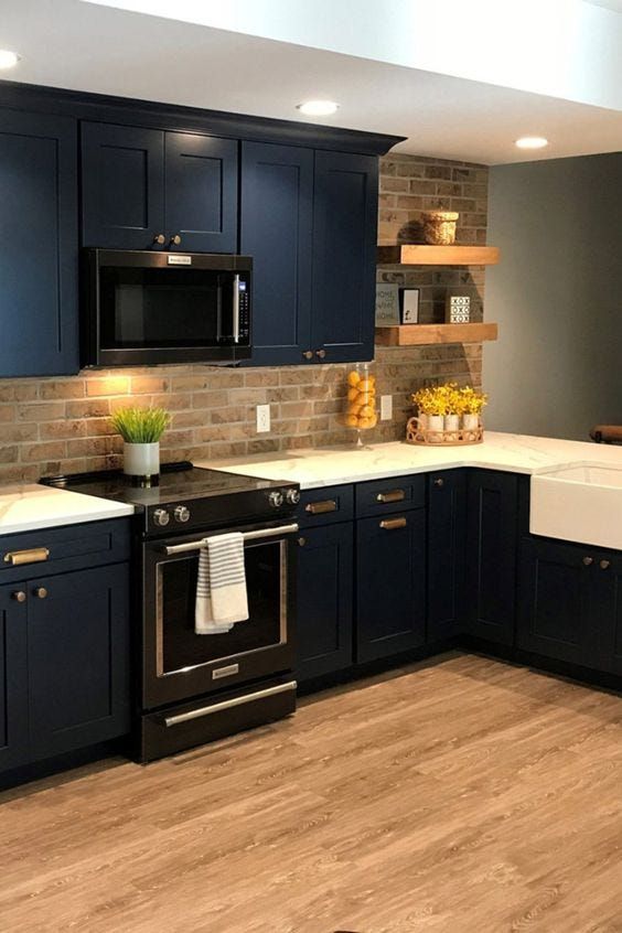 a kitchen with dark blue cabinets and white counter tops