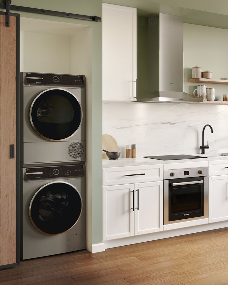 a kitchen with white cabinets and appliances in the corner next to an open door that leads to a washer and dryer