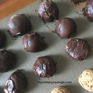 chocolate covered cookies are lined up on a baking sheet