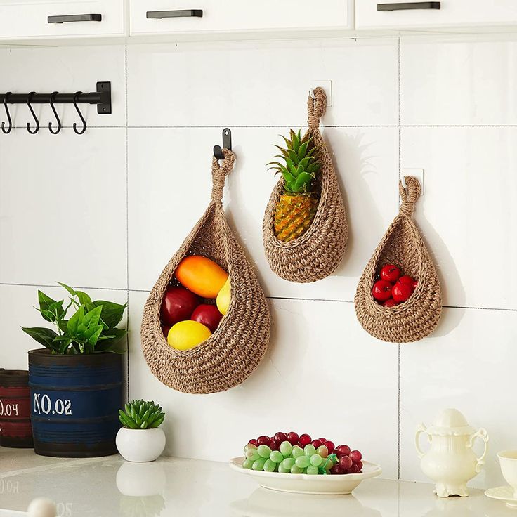 there are two baskets hanging on the wall with fruit in them and one has a pineapple