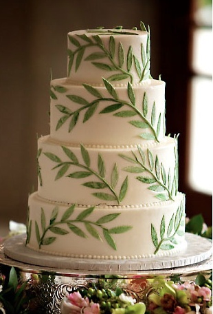 a wedding cake with green leaves on it