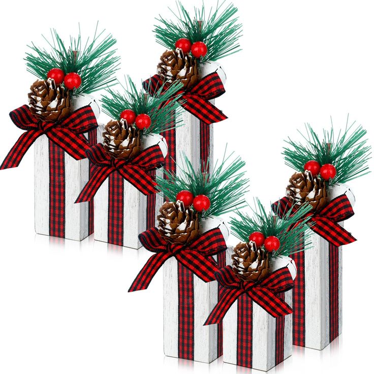 three christmas gift boxes with pine cones and red berries on them, tied in plaid ribbon