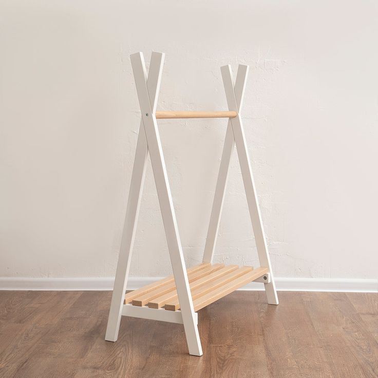 a white wooden shelf sitting on top of a hard wood floor