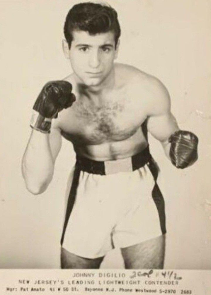 an old black and white photo of a man with boxing gloves on his chest, posing for the camera