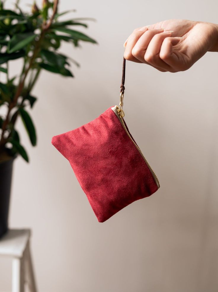 Made with a red sueded fabric, lined with a bird print cotton, and finished with a brown suede zipper pull, you'll adore this sweet and stylish little pouch. These purses are a perfect size for little things, like credit cards and cash. Your undersized items can tuck in here, and fit into a bigger purse or pocket. The sturdy brass zippers make them easy to use. 5.5" X 3.75" Designed and handmade at the Ash & Rose studio in Massachusetts Limited edition Red Pouch With Cell Phone Pocket For Everyday Use, Red Zipper Pouch Wallet Clutch, Red Clutch Pouch For Daily Use, Red Bag With Zipper Pouch As Gift, Red Bag With Zipper Pocket For Gift, Red Clutch Wallet With Zipper Pouch, Clutch Coin Purse With Zipper Pocket As Gift, Clutch-shaped Coin Purse With Zipper Pocket As Gift, Red Zipper Clutch Pouch