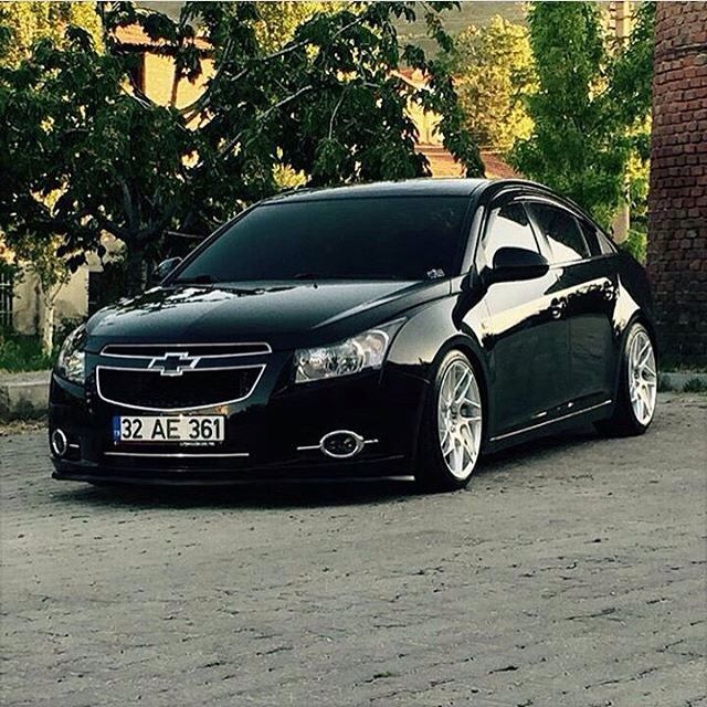 a black car parked in front of a brick building