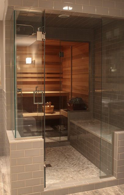 a glass enclosed sauna in the middle of a bathroom