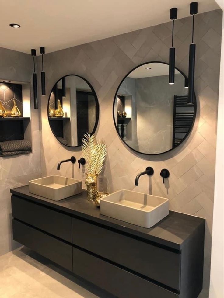 a bathroom with two sinks and mirrors on the wall