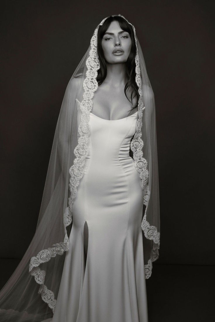 a woman in a wedding dress with a veil over her head