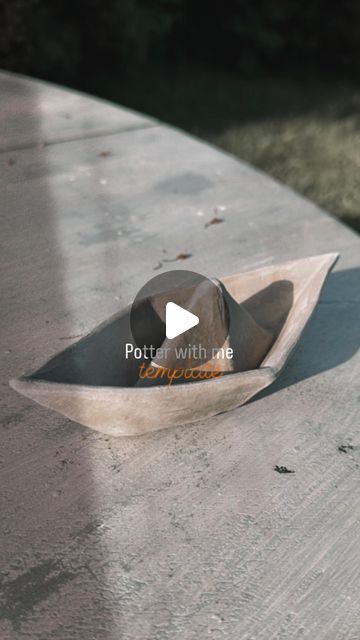 a wooden boat sitting on top of a cement table