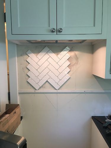 the kitchen is being remodeled with white tile on the backsplash and blue cabinets