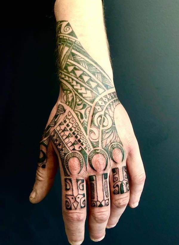 a person's hand with a tattoo on it and an intricate design in the middle